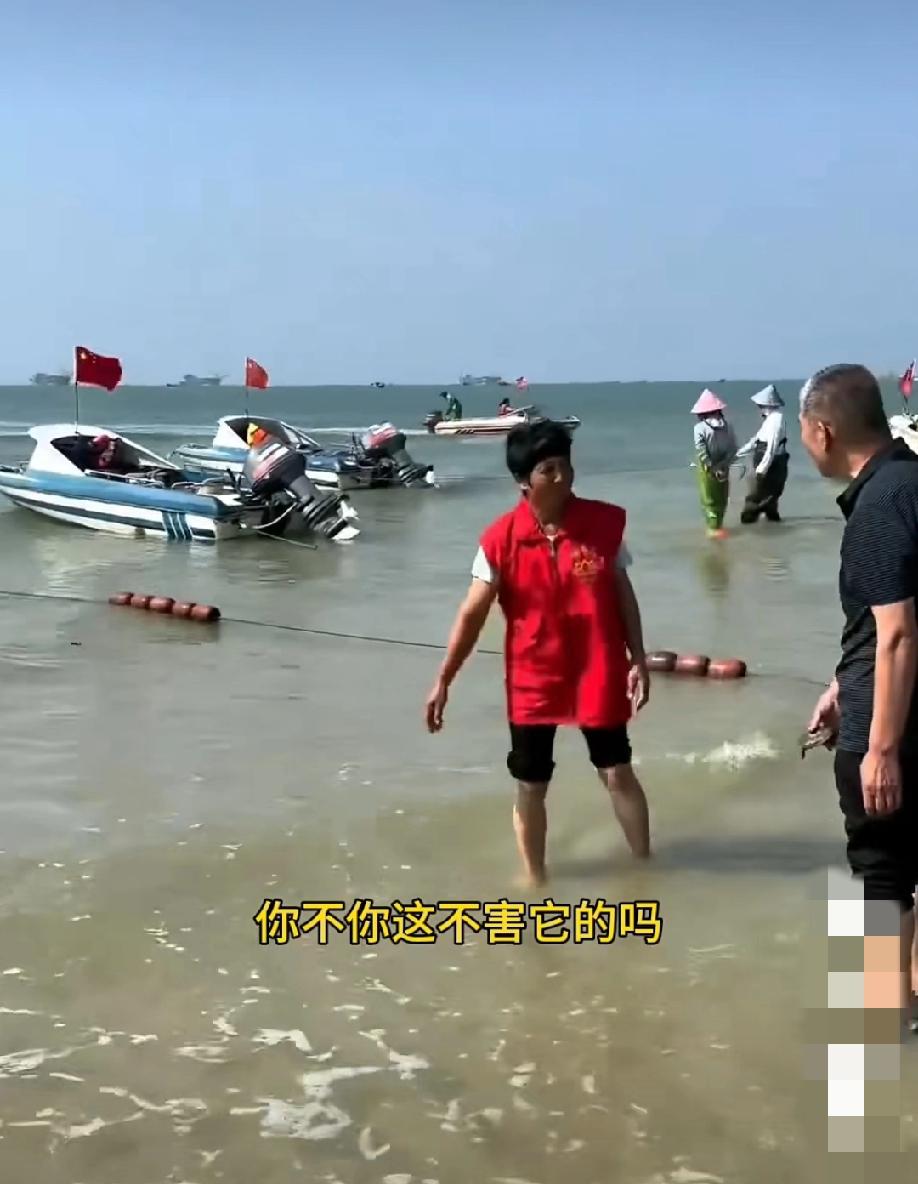 1月17日。广西北海银滩景区。一群人往海里放生淡水生物！一位大哥劝阻道:“你这