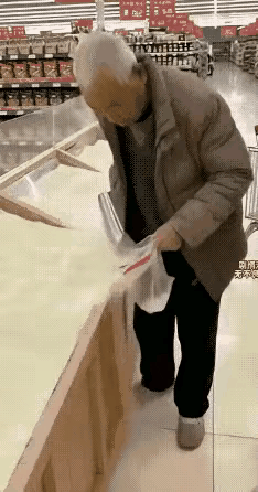 太心痛了！超市里，老人拿着袋子舀米，进袋子里的少，撒在地上的多。售货员看见满地都