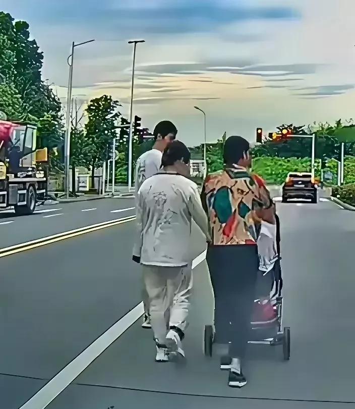 走自己的路，让别人无路可走！这一家三口，推着婴儿车，走在马路正中央的直行车道上