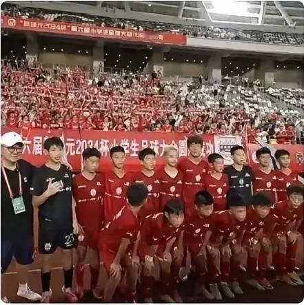 赢了比赛，庆功宴菜还没上桌，董路青训这帮孩子先掏出零食啃上了。抱着礼物回座位