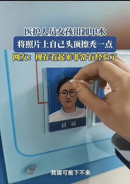 笑不活了！医院医护人员照片墙前，一个女子拿着纸巾，对着墙上一张女生的工作照偷摸的