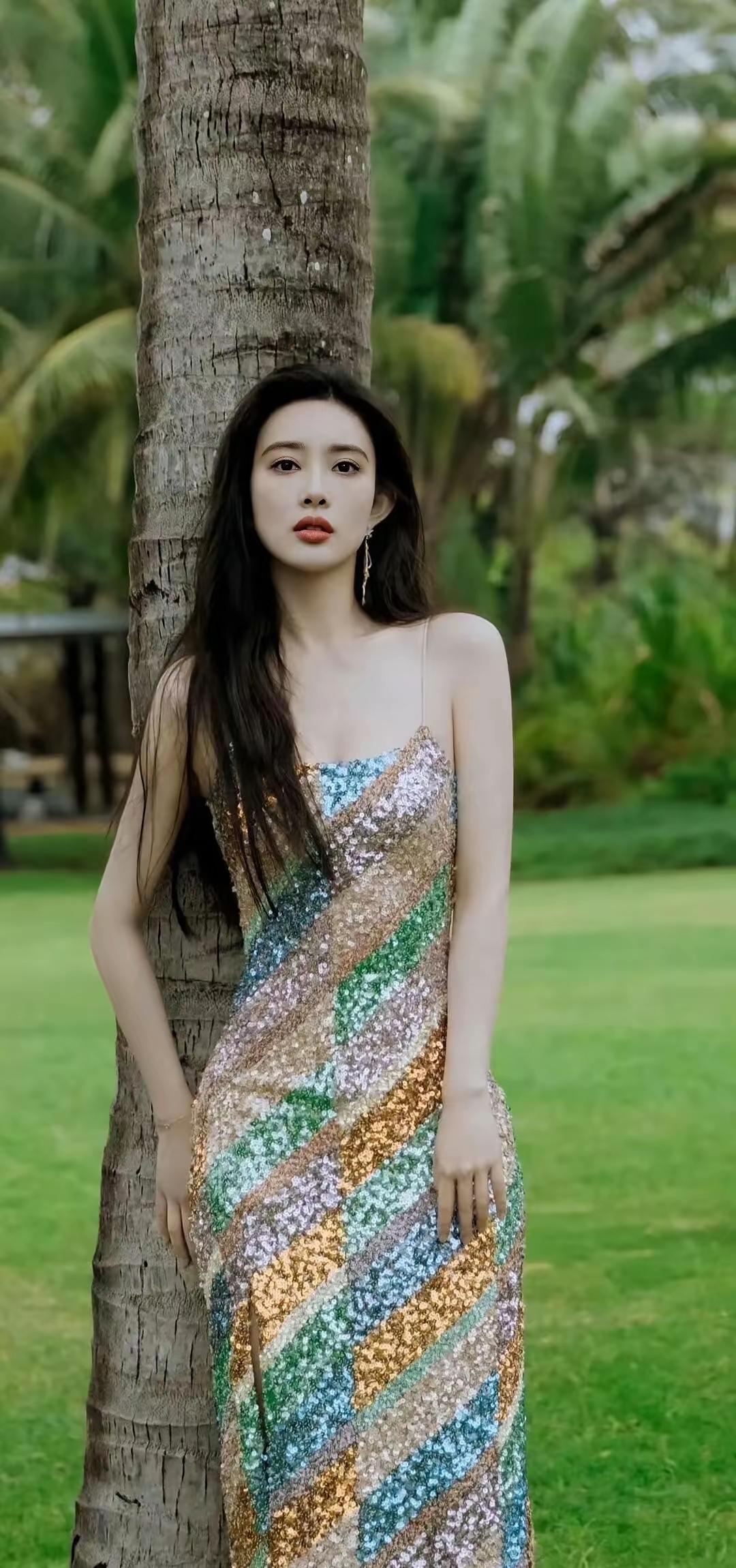 孟子义，一袭彩片吊带裙在光影中流转生辉。每一片亮片都缀着海边的浪漫，以潮汐为幕