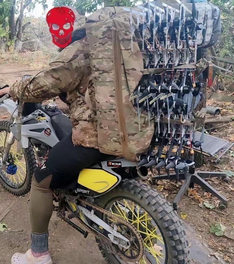 俄军士兵骑着摩托运送着无人机，现在无人机在战场上可是抢手货啊，俄军士兵很多人都希