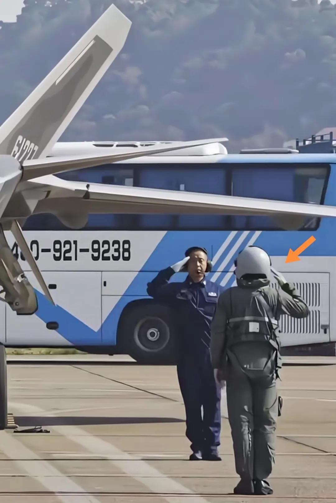歼-20飞行员登机前向地勤工作人员敬礼。