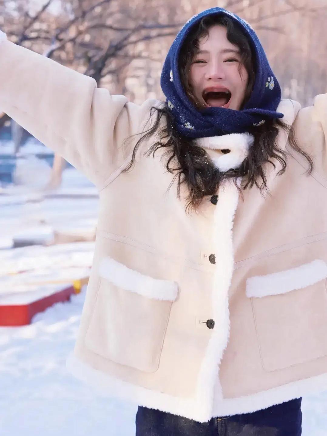 马思纯在长春初雪中撒欢，奶黄色毛绒外套与红墙白雪相映成趣，她像个孩子般接雪、奔跑