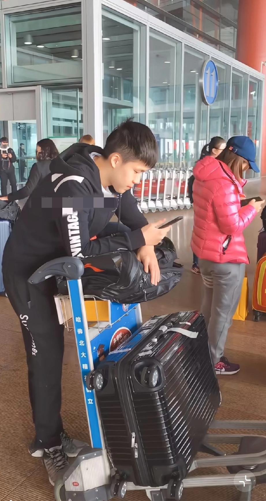 刷到王楚钦这张机场照片，真的有点感慨。镜头里的他，还是那个低头看手机、推着行李