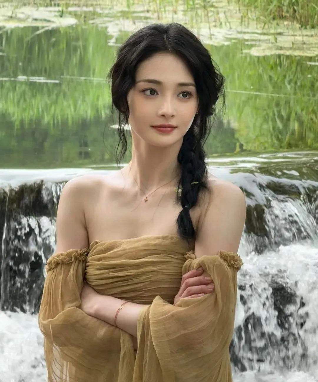 周洁琼的这组物料太绝啦！她穿着抹胸薄纱裙，在流水边或坐或卧，发丝微扬，眼神温柔又