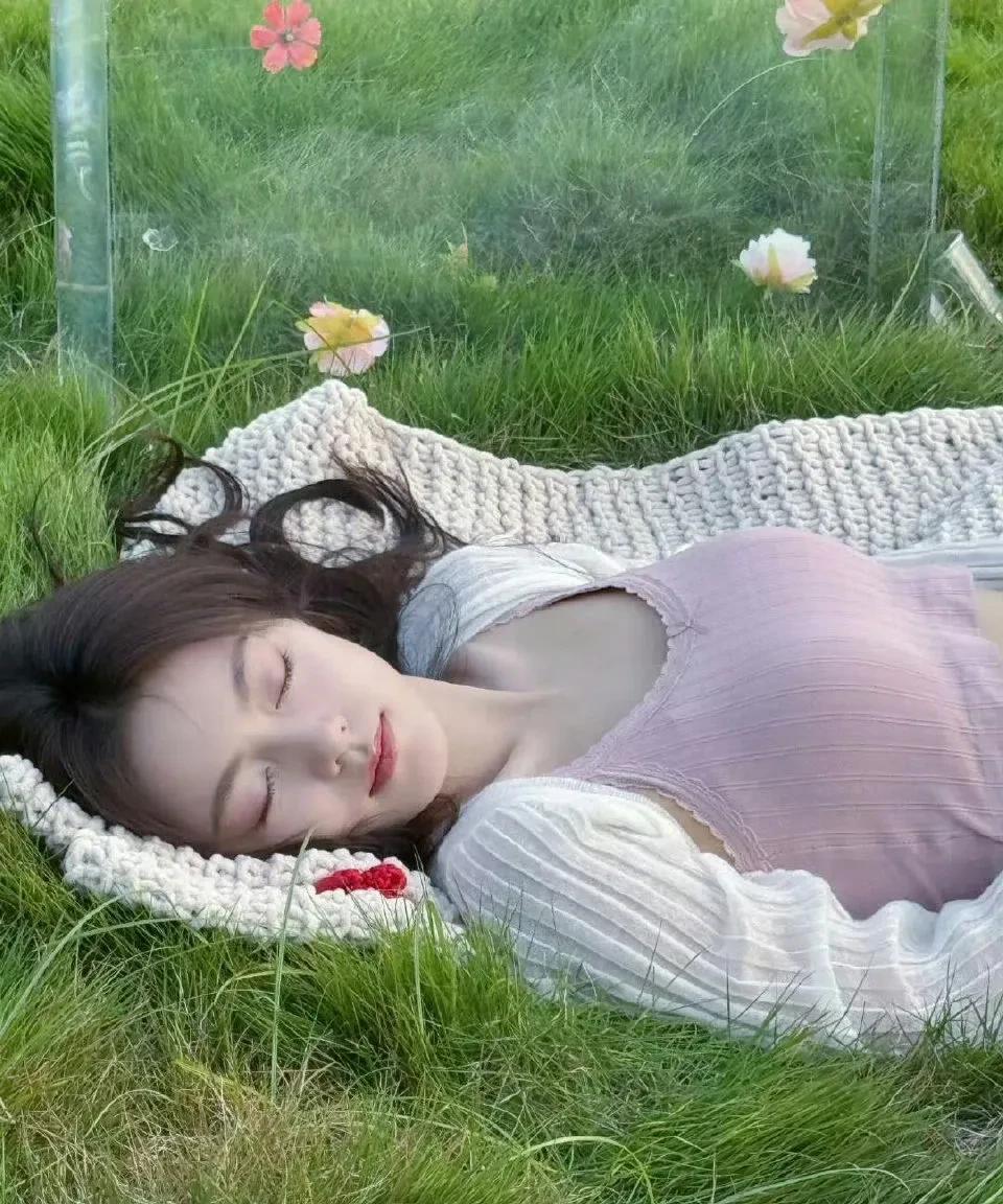 在草地与微风的环抱里，粉色背心搭配浅色短裙，满是清新与活力。发丝随微风轻舞，每一