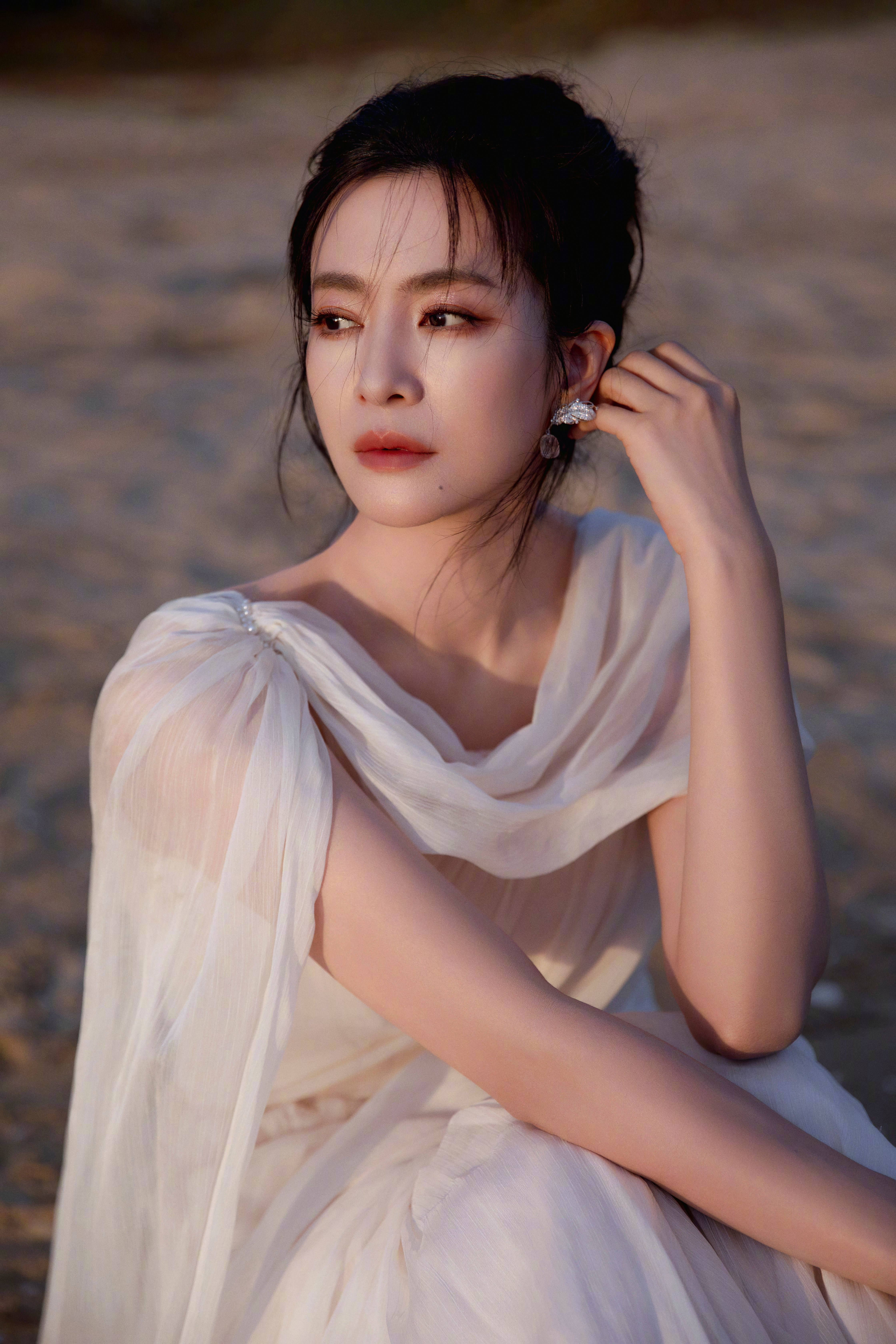 李晟浅纱斜肩长裙勾勒出绝美的身形线条，斜肩设计露出来的肩颈弧度清艳又勾人。