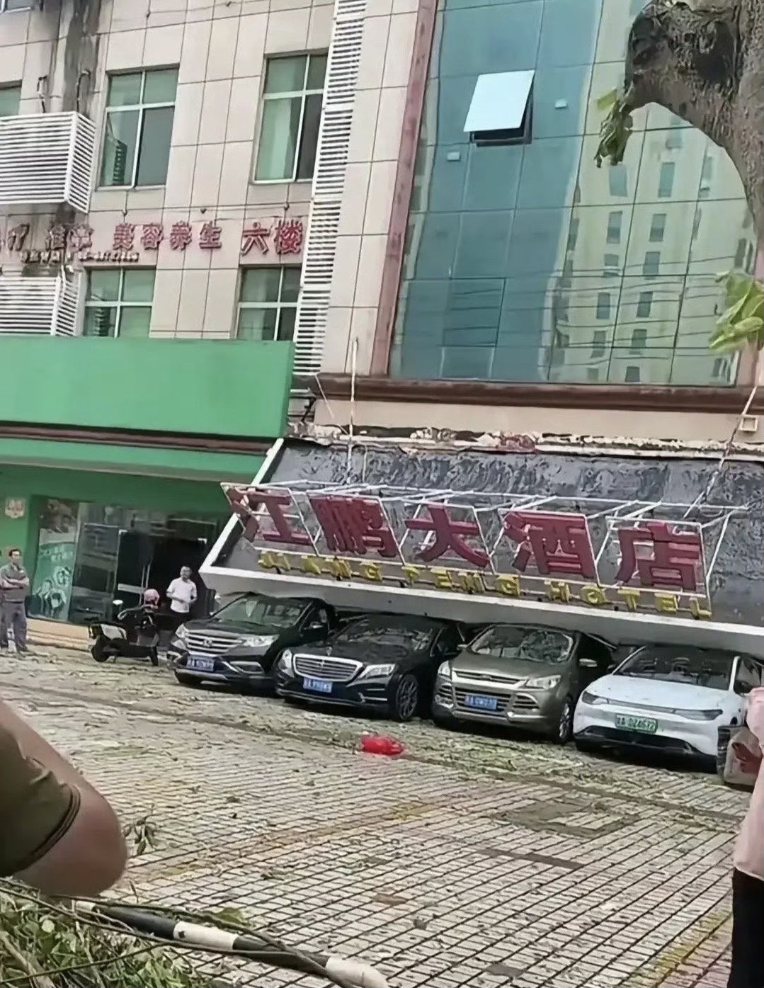 幸好有这四辆车撑住，要不招牌就坏了