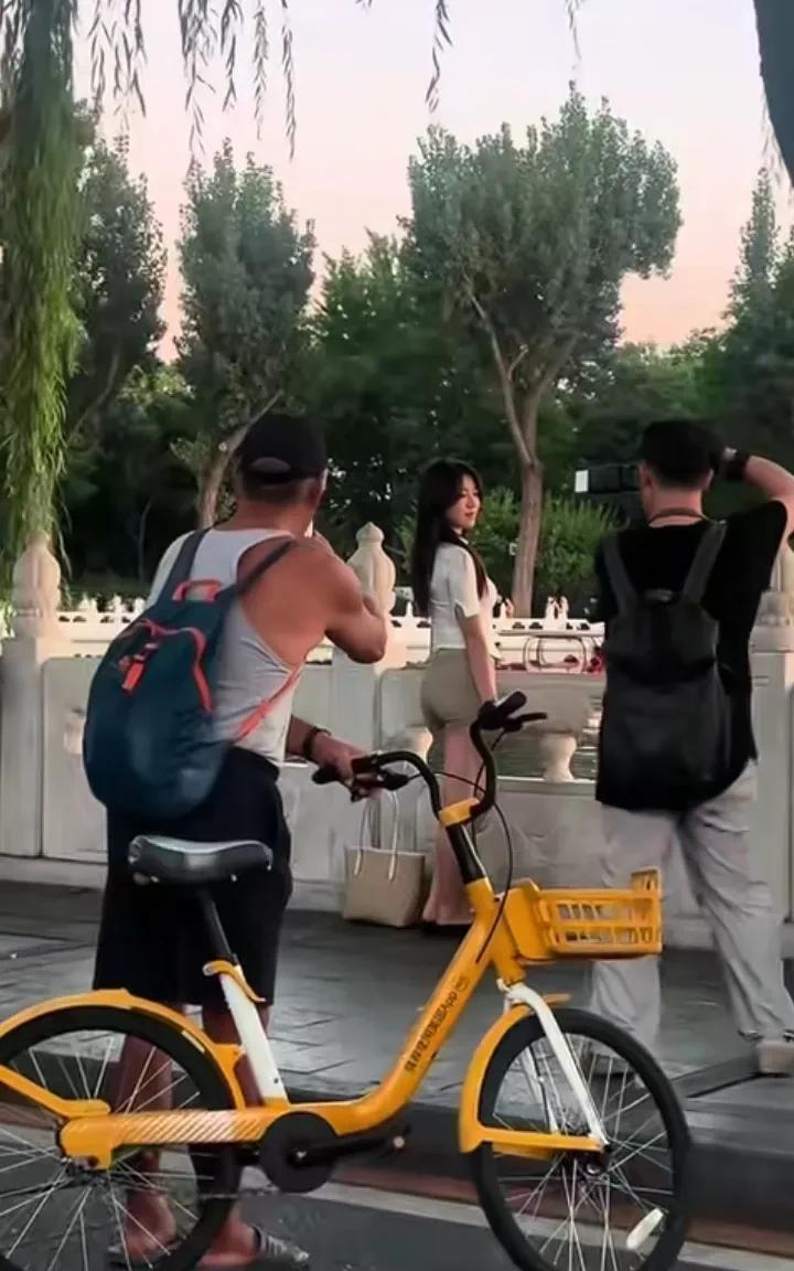 “螳螂捕蝉，黄雀在后”，摄影师给美女拍照，大爷也趁机拍了几张，又有人拍到大爷和摄