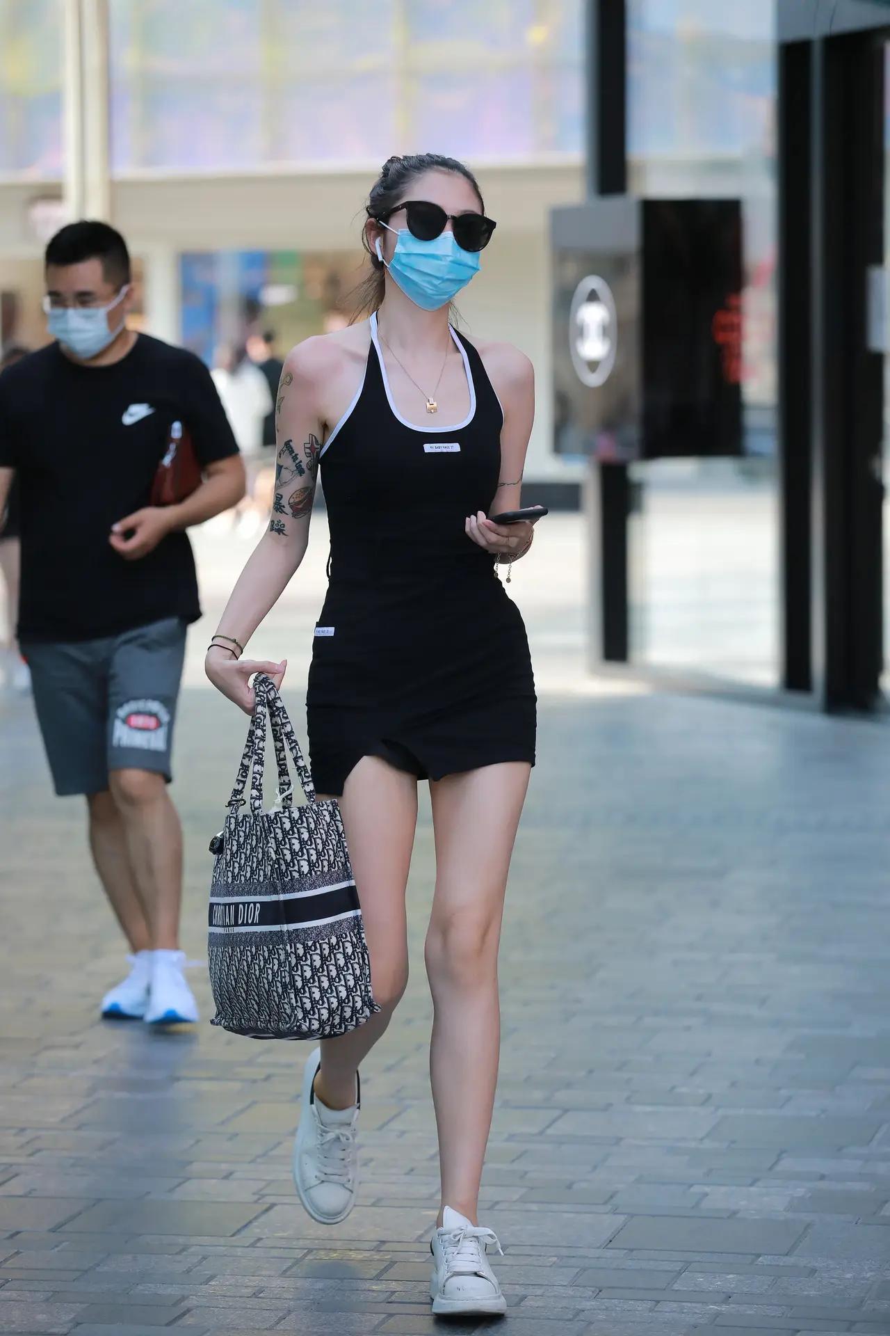 戴着口罩和墨镜的时尚女生在逛街。微胖身材该怎么穿搭女生怎样穿才能显得身材好挺拔
