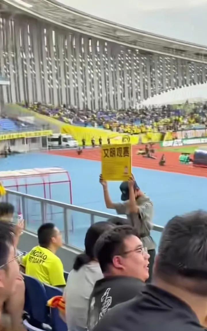 青岛德比两队球迷整齐划一的wcnnn国骂声和倒数第一的讽刺声，举着“文明观赛”牌