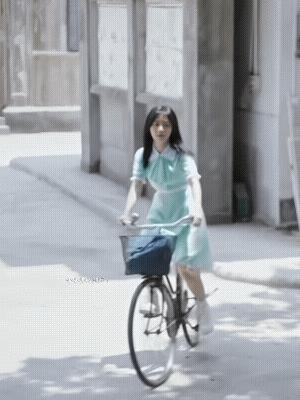 迎面骑过来一个长发飘飘的美女，差点认不出啊！她穿着青草绿的连衣裙，裙摆飞扬，身段