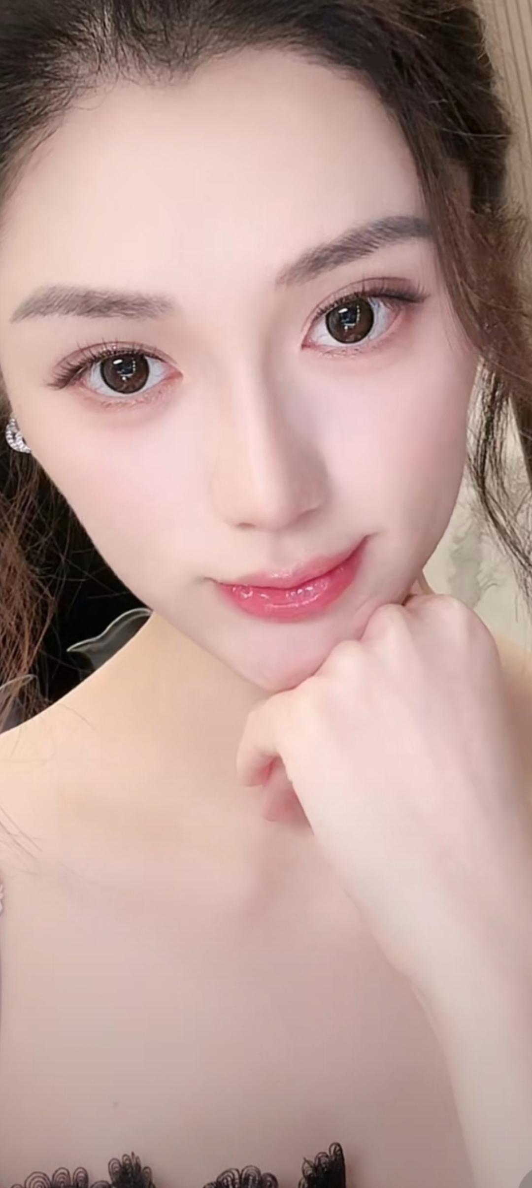 这位美女正在微笑，手托着下巴。