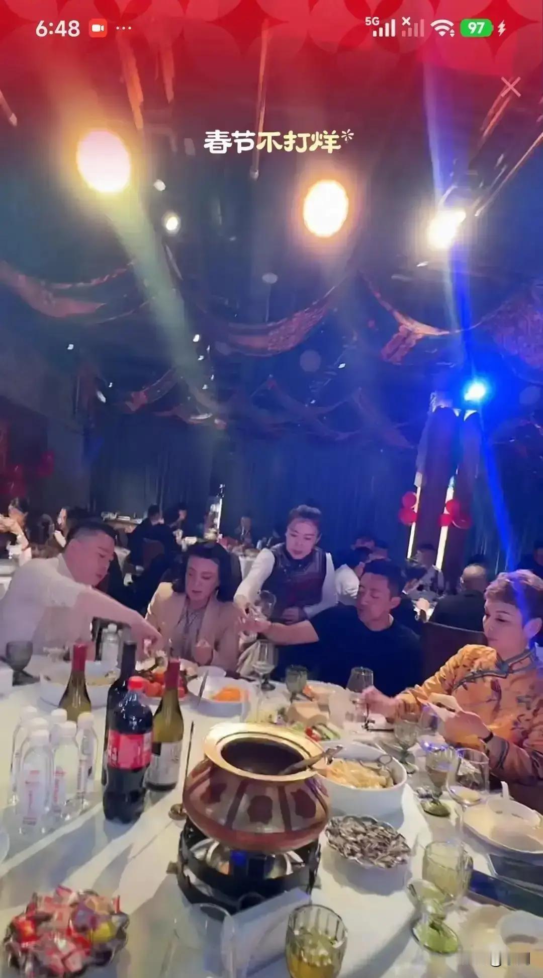 汪小菲在麻六记年会上一身红西装，端着酒杯挨个桌敬酒，镜头扫过去，他脸已经通红，说