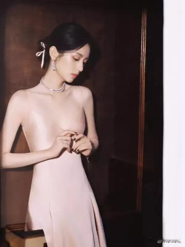 近日活动现场，周也宛如从梦幻画卷中走出的仙子。她以低盘发造型亮相，搭配一袭粉色吊