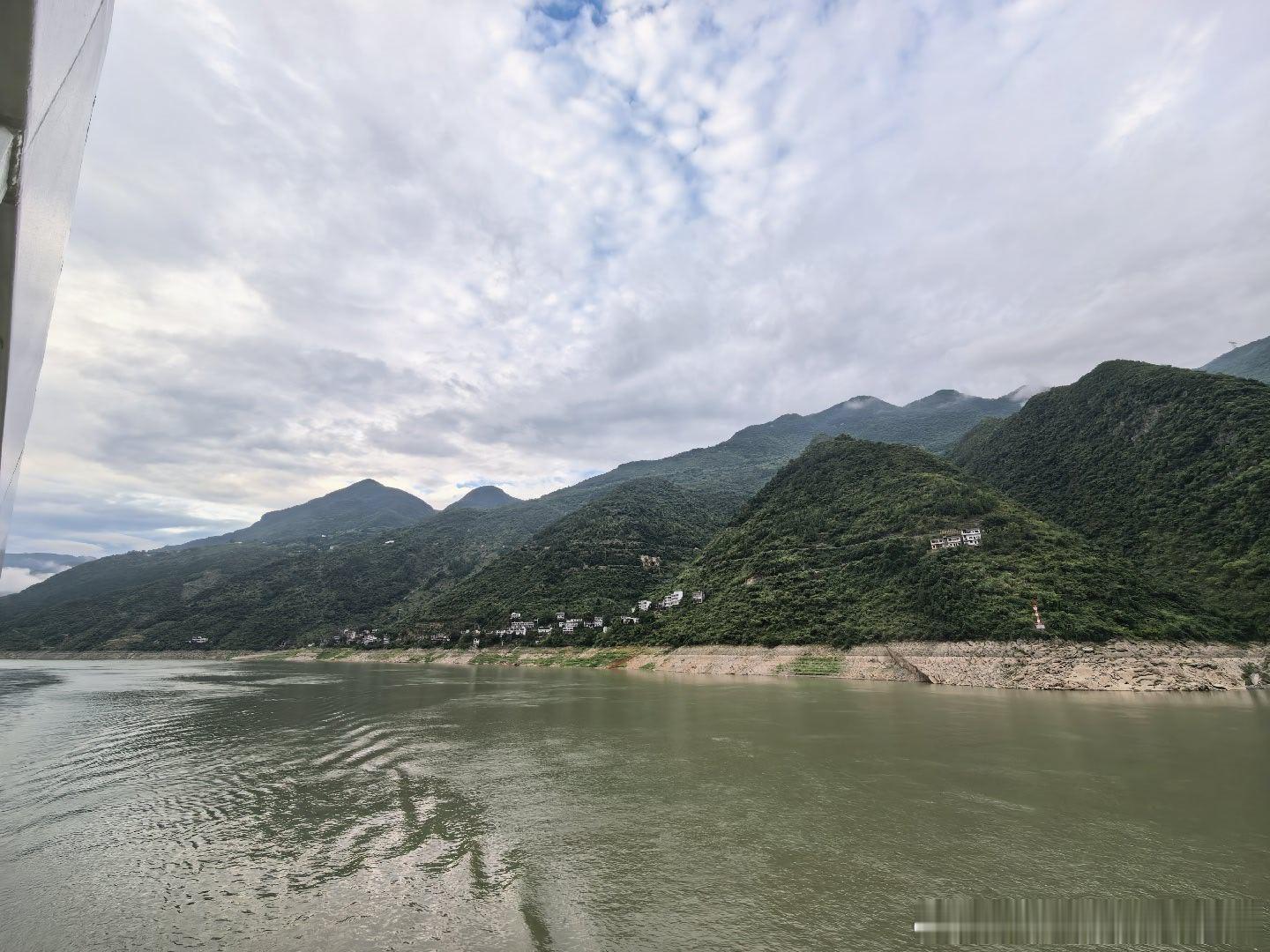 岸上青山自带踢脚线，坡上白墙围成很多房子，水上驳船兜着东风大卡，天上白云扯成一坨