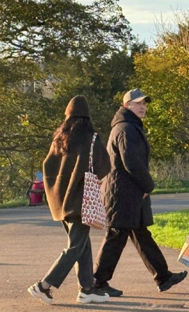 沙溢同妻子胡可在英国游玩逛街，初冬的英国街头也很寒冷，沙溢和老婆都裹着厚重的羽绒