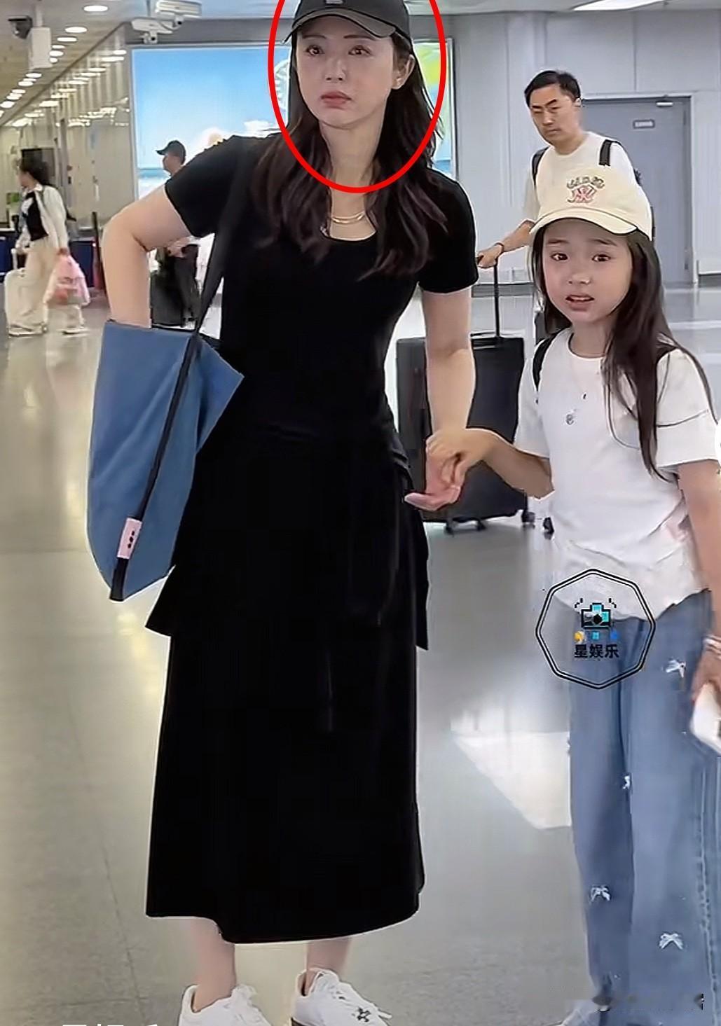 感觉董璇长了一张苦相脸，四十多岁的她越来越明显！机场中她细心的给孩子拿出用纸