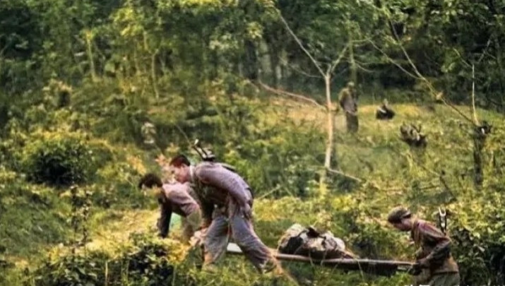 1988年，老山前线，战友们抬着唐道权烈士残破的遗体回国。这位重庆籍侦察排长