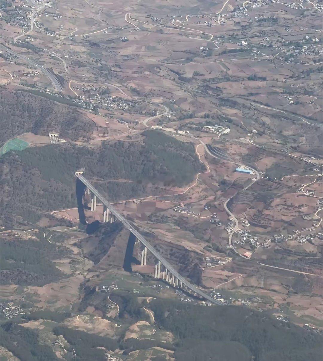 云南某高架公路，网友认为可以从右边绕过去没有必要架桥和打山洞隧道，成本会低很多