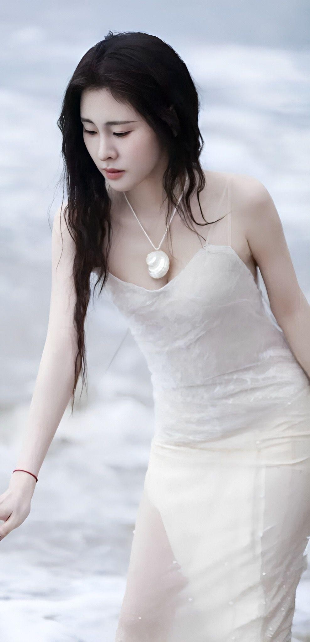 张碧晨风把浪声揉进发梢你踏过潮汐白裙沾着海盐的凉贝壳项链悬在胸口像海的