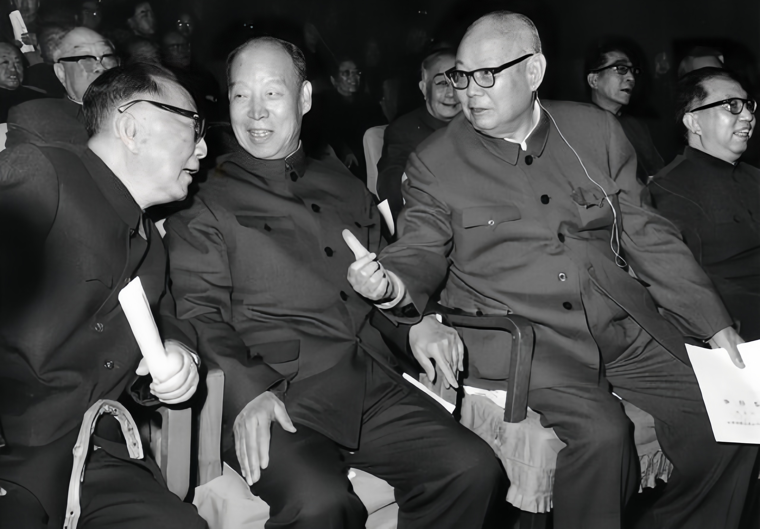 这是一张经典照片，叶剑英隔着一人和聂荣臻说话，他们两位是排名最末的元帅。中间那人
