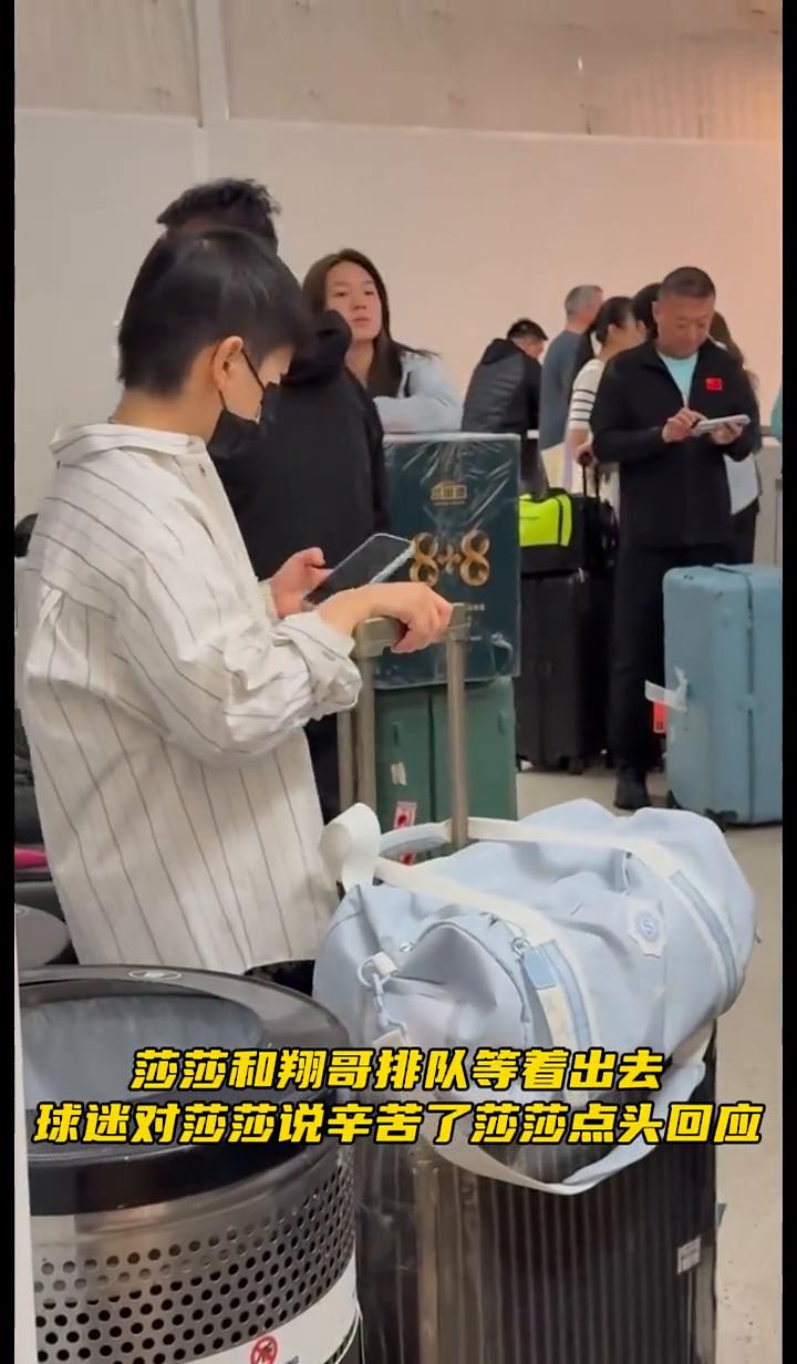 莎莎和翔哥排队等着出去，球迷对莎莎说辛苦了，莎莎点头回应。莎莎圆圆的大眼睛好可惜