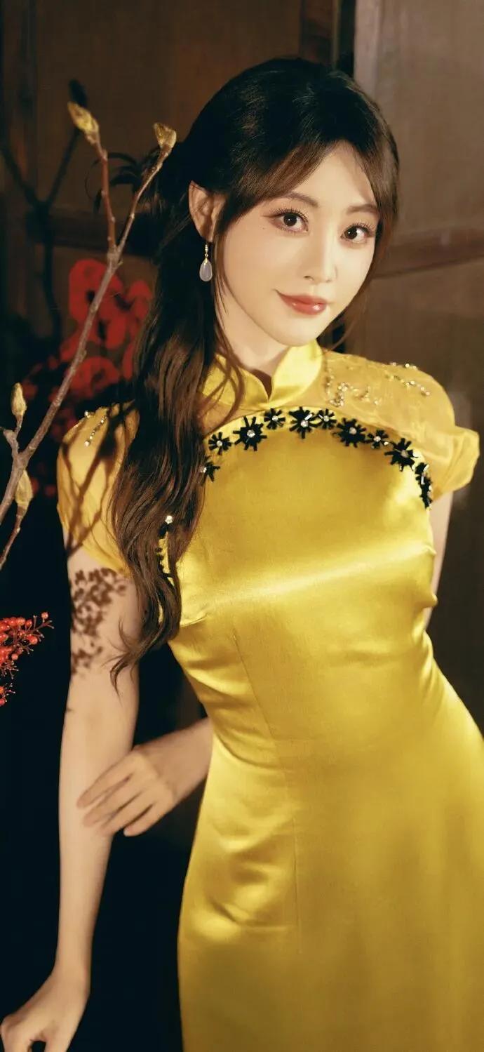 美女壁纸～祝绪丹，明黄缎面旗袍则晕开暖光，珠花与玉耳坠衬得温婉明艳，执扇或点红的