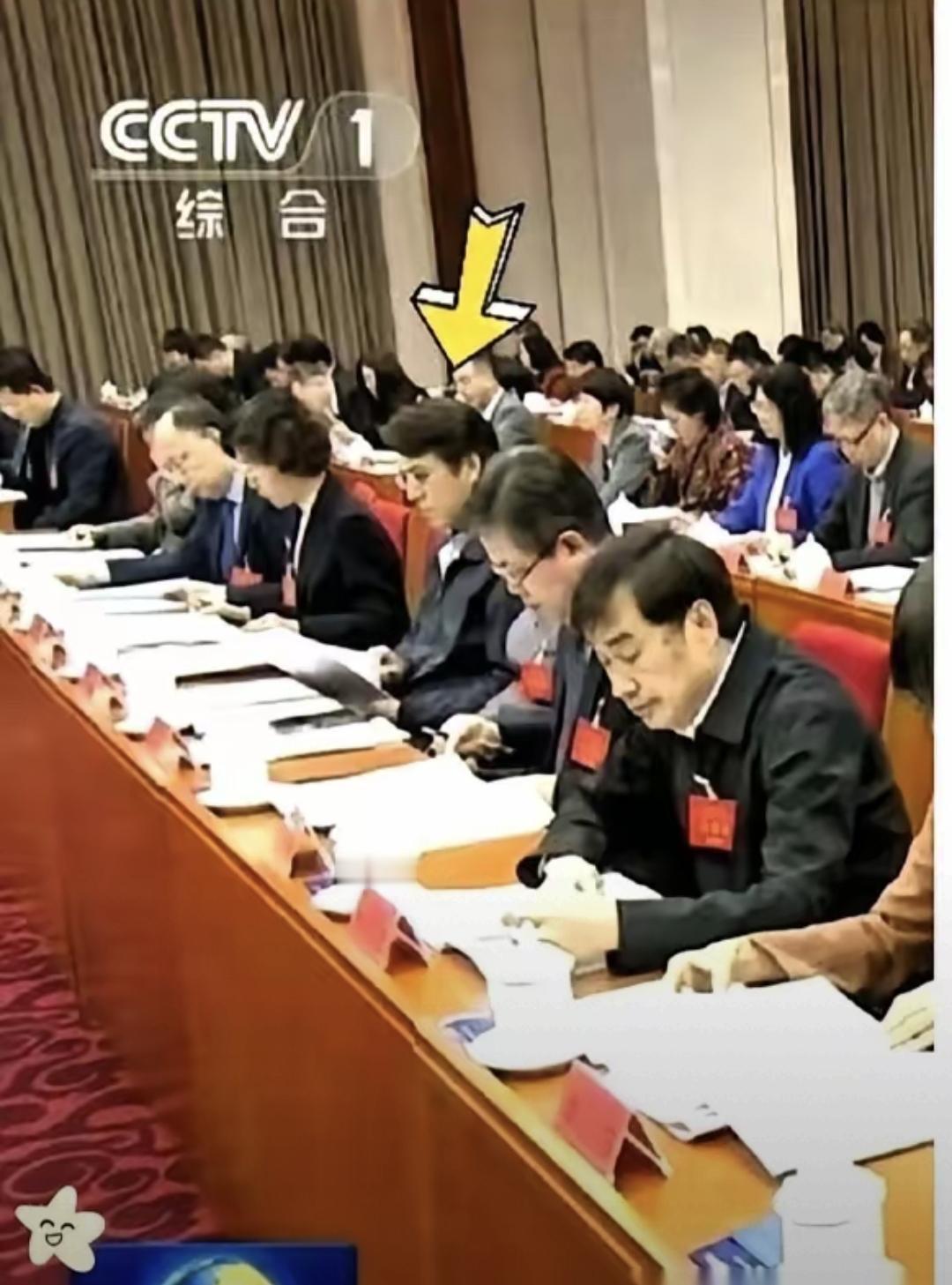 昨天晚上看《新闻联播》，中间一个会议画面，坐在第三排那个戴金丝眼镜、穿深蓝夹克的