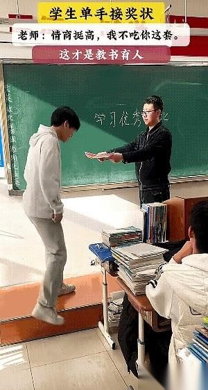 那张红色的奖状，老师递到一半，手突然就停住了。台上的男孩伸手去接，够不着。他又