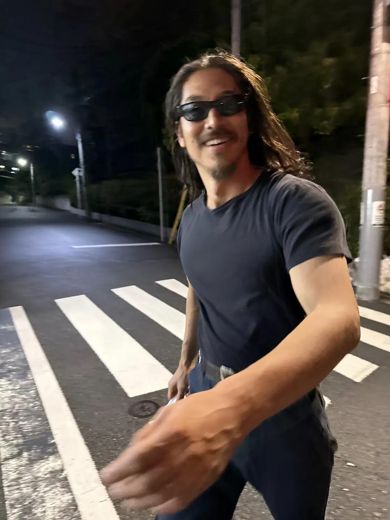林志玲老公黑泽良平在晚上的街头出现，打扮真的一言难尽，留着一头长发，胡须没刮，不