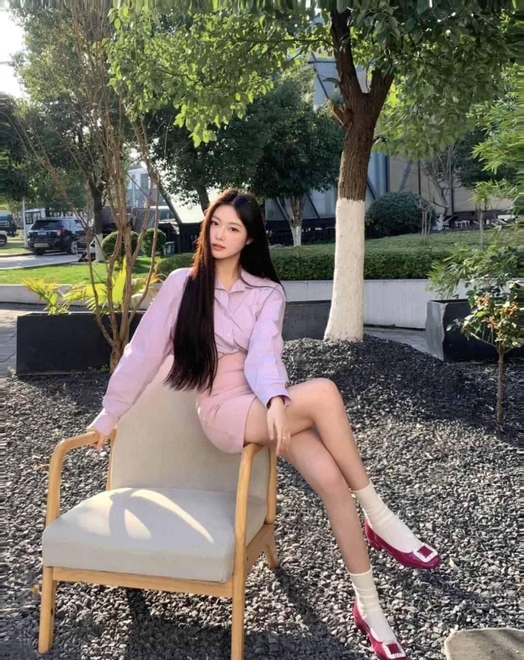 淡紫衬衫揉着温柔的春日氛围，在户外的碎石地面旁闲坐，玫红单鞋撞出点睛的甜酷，让慵