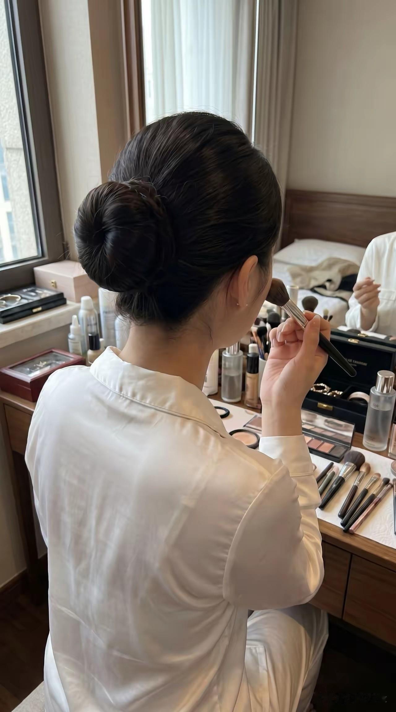 从坐姿再看这么多化妆品，再看她的发型，我猜她是空姐