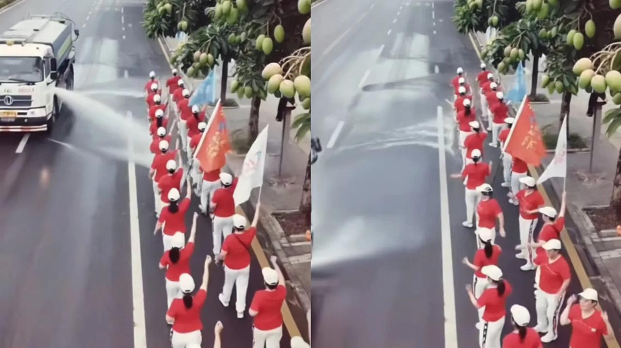 第一次觉得洒水车竟这么可爱！一群大爷大妈正在公路上暴走，这时一辆环卫洒水车也由远