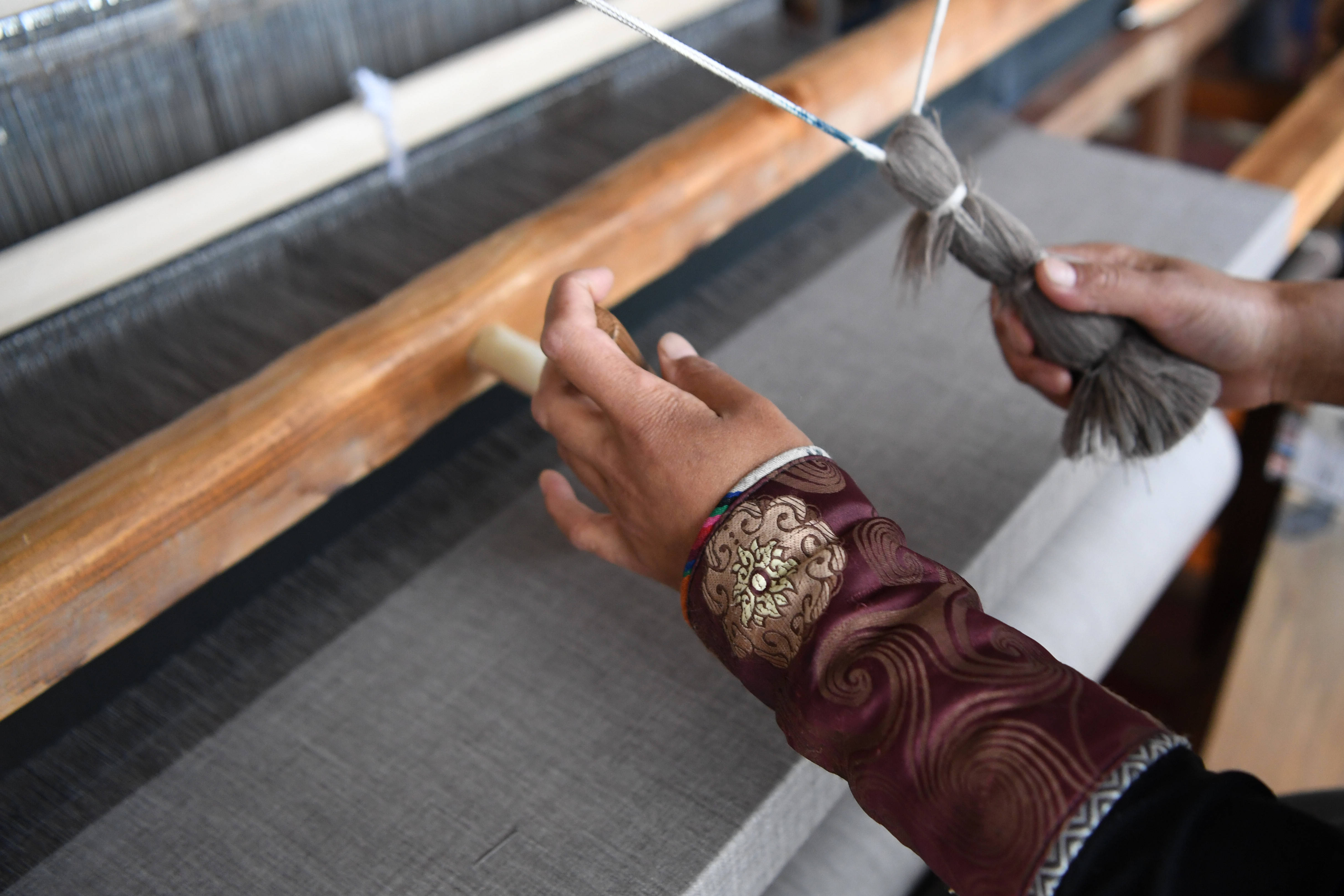 加科村村民周毛吉使用传统木式纺织机编织手工艺品(9月9日.