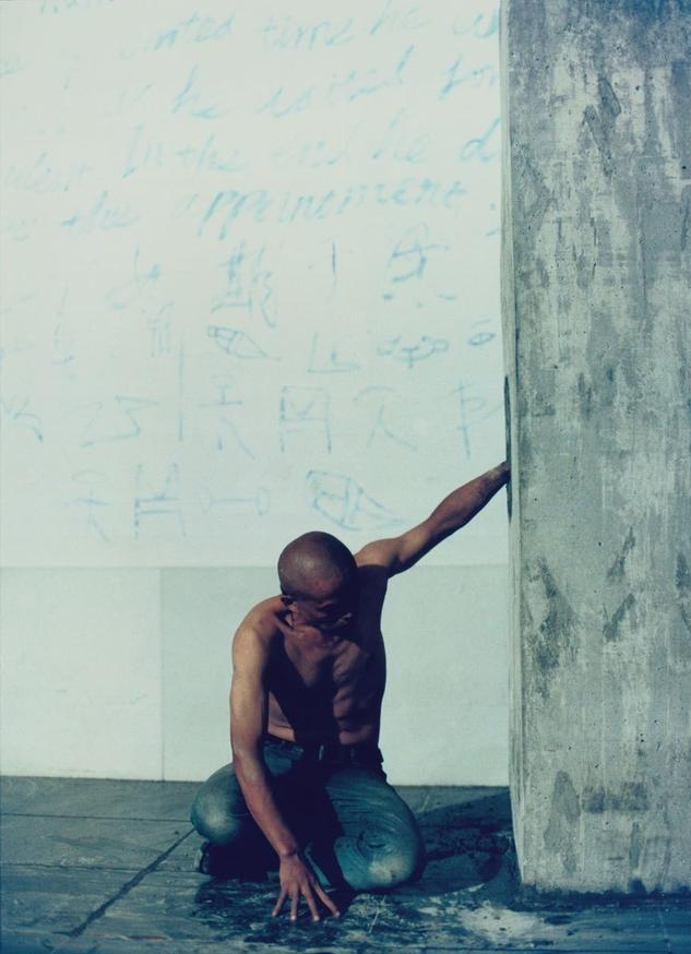 2003年，在云南丽江街头，一个男子把自己的手浇筑在水泥墙里，直至墙面干透，路过