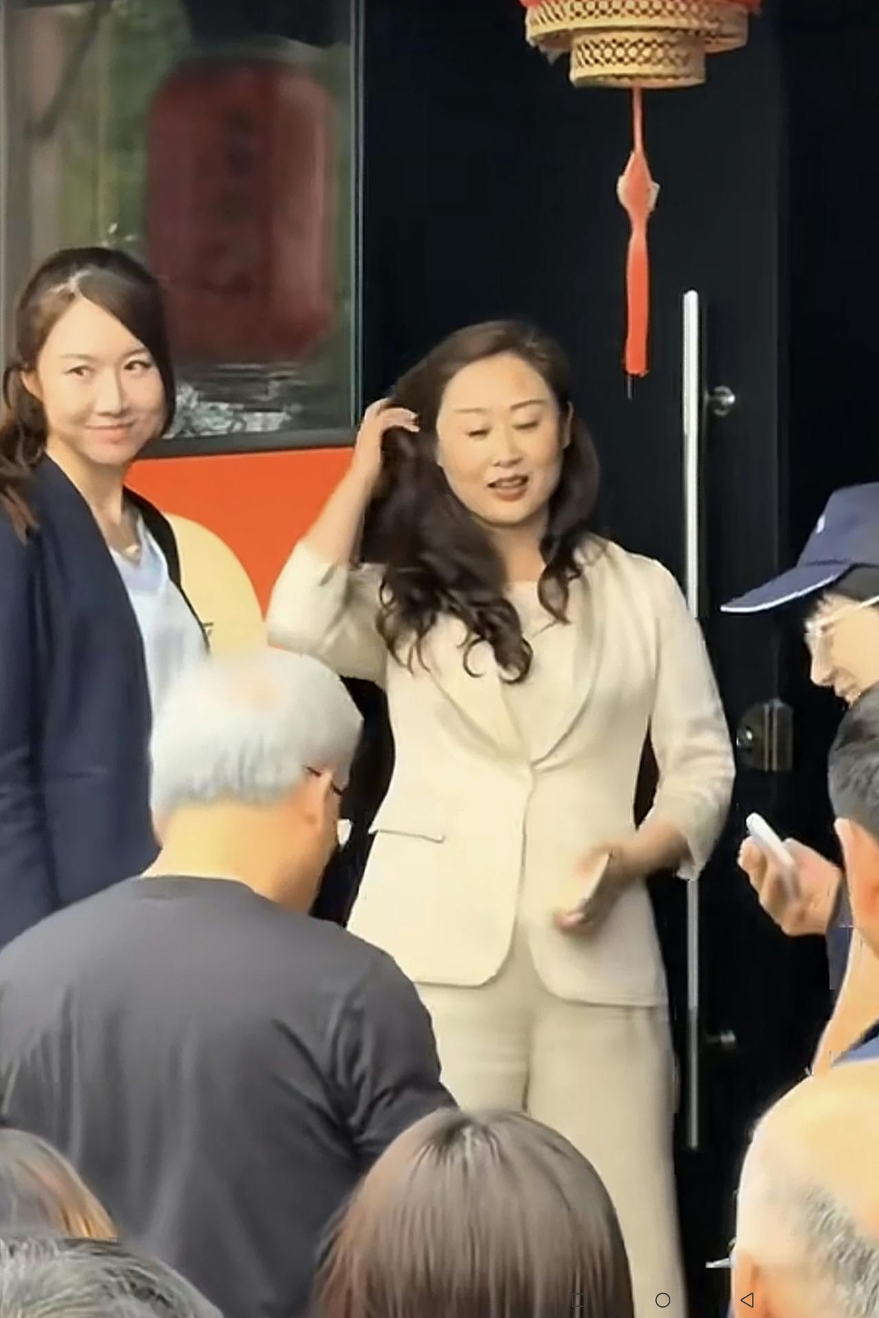 黄仁勋与庆云楼老板娘合影细节曝光：漂亮的庆云楼老板娘在饭店门口手理长长的披肩发