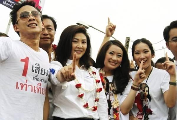 他信儿子身旁站在三个大美女，一个是他姑姑英拉，一个是他姐姐萍通塔，一个是他妹妹佩