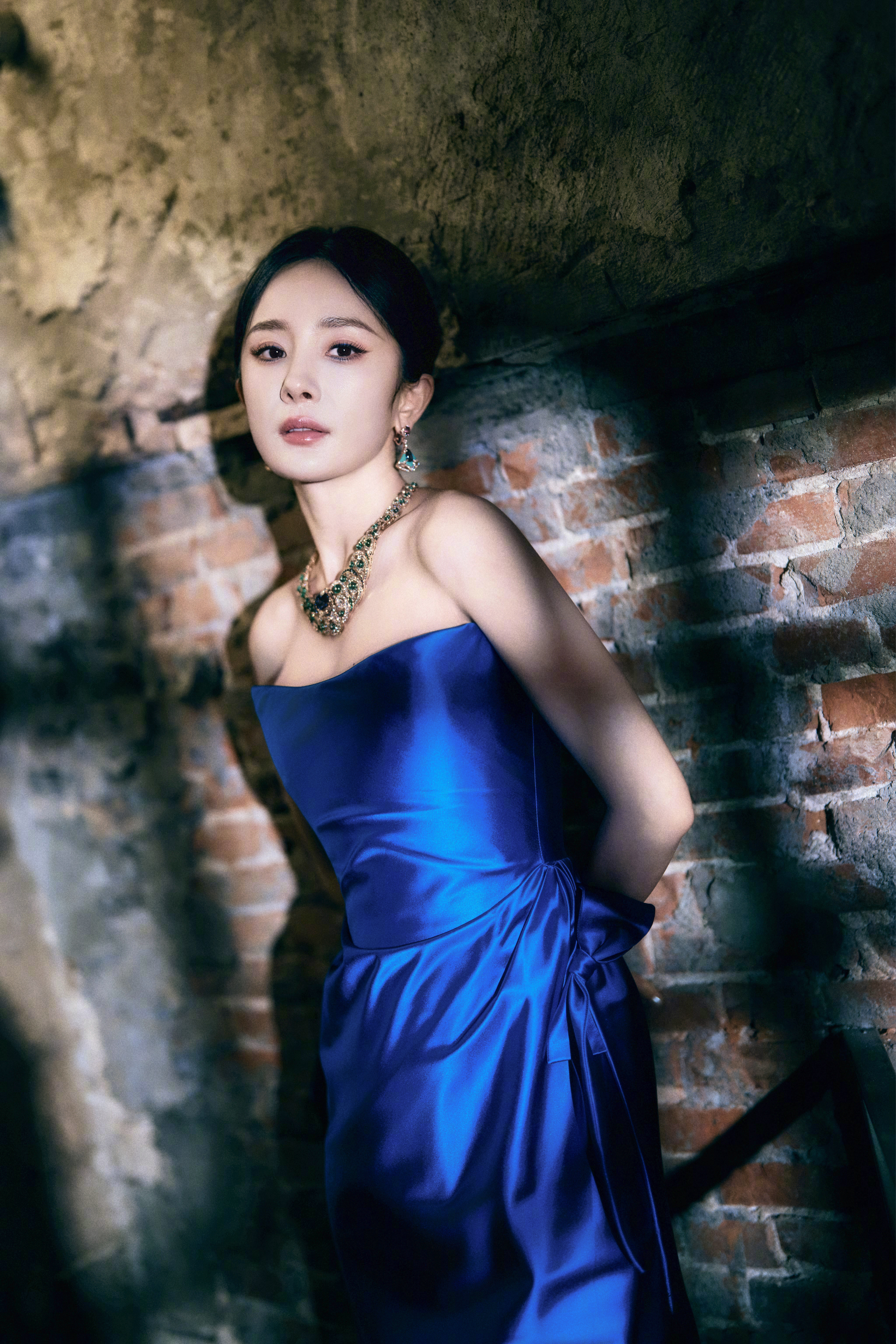 杨幂一袭宝蓝礼裙勾勒曼妙身姿，丝带轻绕、高跟点睛，在明暗交错间，演绎冷艳与优雅