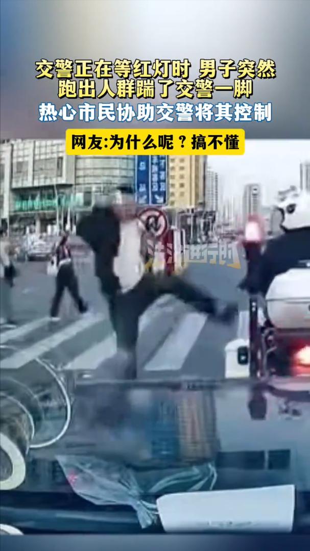 看不懂！一名交警骑着摩托在等红灯，一名男子突然从人行道上的人群中窜出，飞起就踹了
