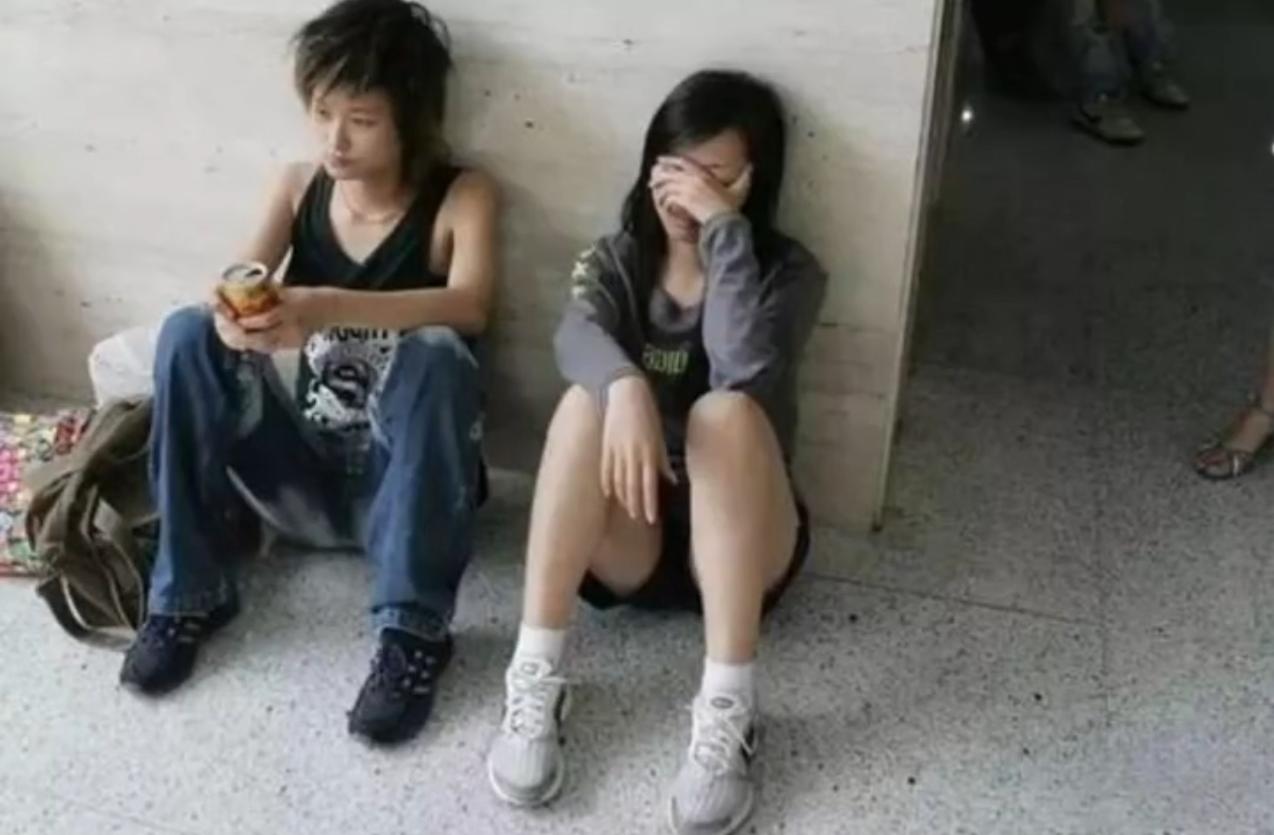 2005年，成名前的李宇春和张靓颖，在成都火车站席地而坐，满脸疲惫。那时候她们