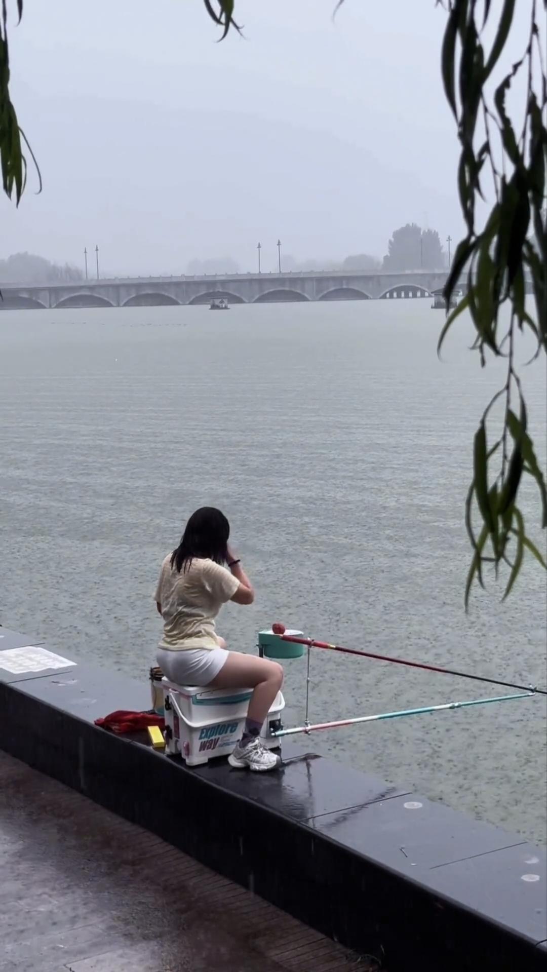 公园美景随拍没想到女钓手中也有狠角儿啊，下雨天钓鱼伞都不打，直接坐在雨中干，身上