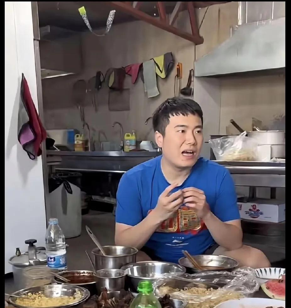 刷到梁靖崑在厨房干饭的画面，直接被这接地气劲儿戳中！桌上不锈钢盆摆满饭菜，杂乱又