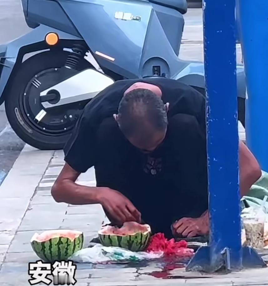 马路边的他，蹲在垃圾桶旁边，可能是因为太过饥饿了，用手抓起发馊的西瓜，啃了起来，