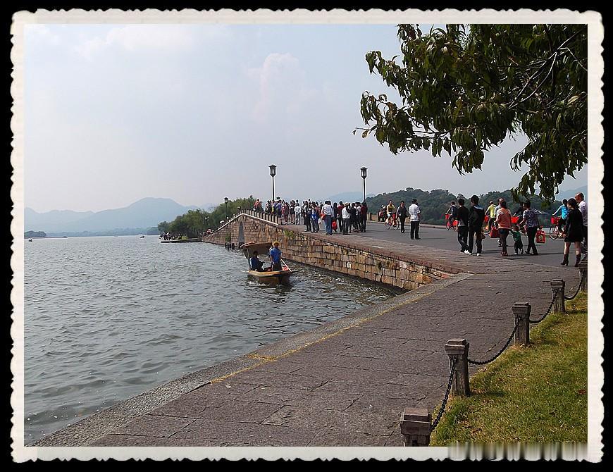 漫步西湖江南岸，一湖山水藏尽温柔人间暖风拂过西湖堤岸，垂柳依依，湖水波光粼粼。