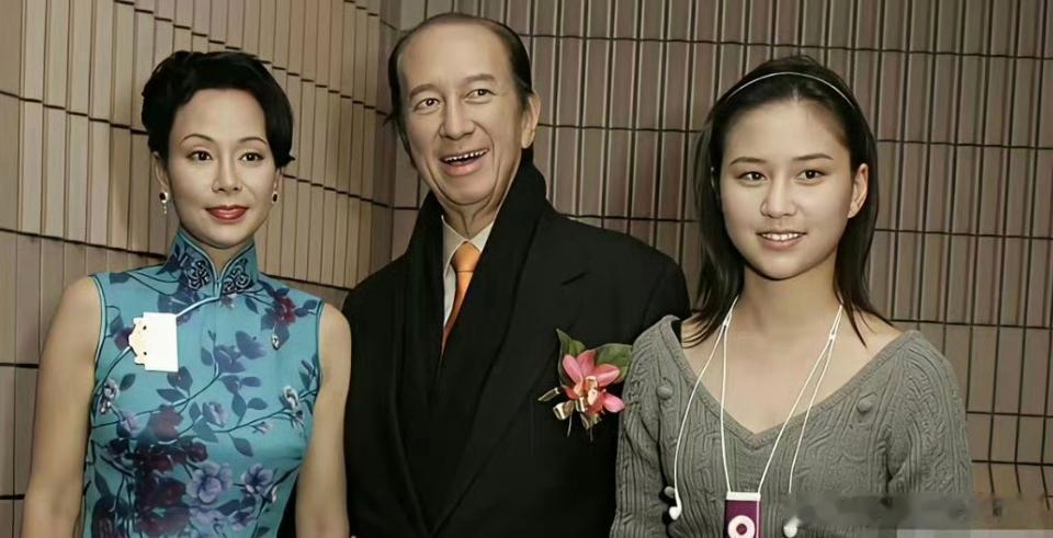 少女时期的何超莲，和爸爸赌王一起拍照，个子小小的，脸蛋圆圆的，看起来还没长开。