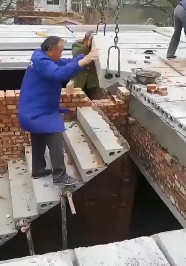 这样搭楼梯，看着很悬啊两层小楼上用链条和起重机安装预制混凝土楼梯踏板，指出施工