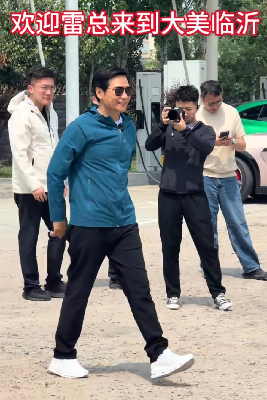 雷军京沪自驾，临沭服务区充电，被网友偶拍，雷总戴一副墨镜，背着双手走，有村里二大